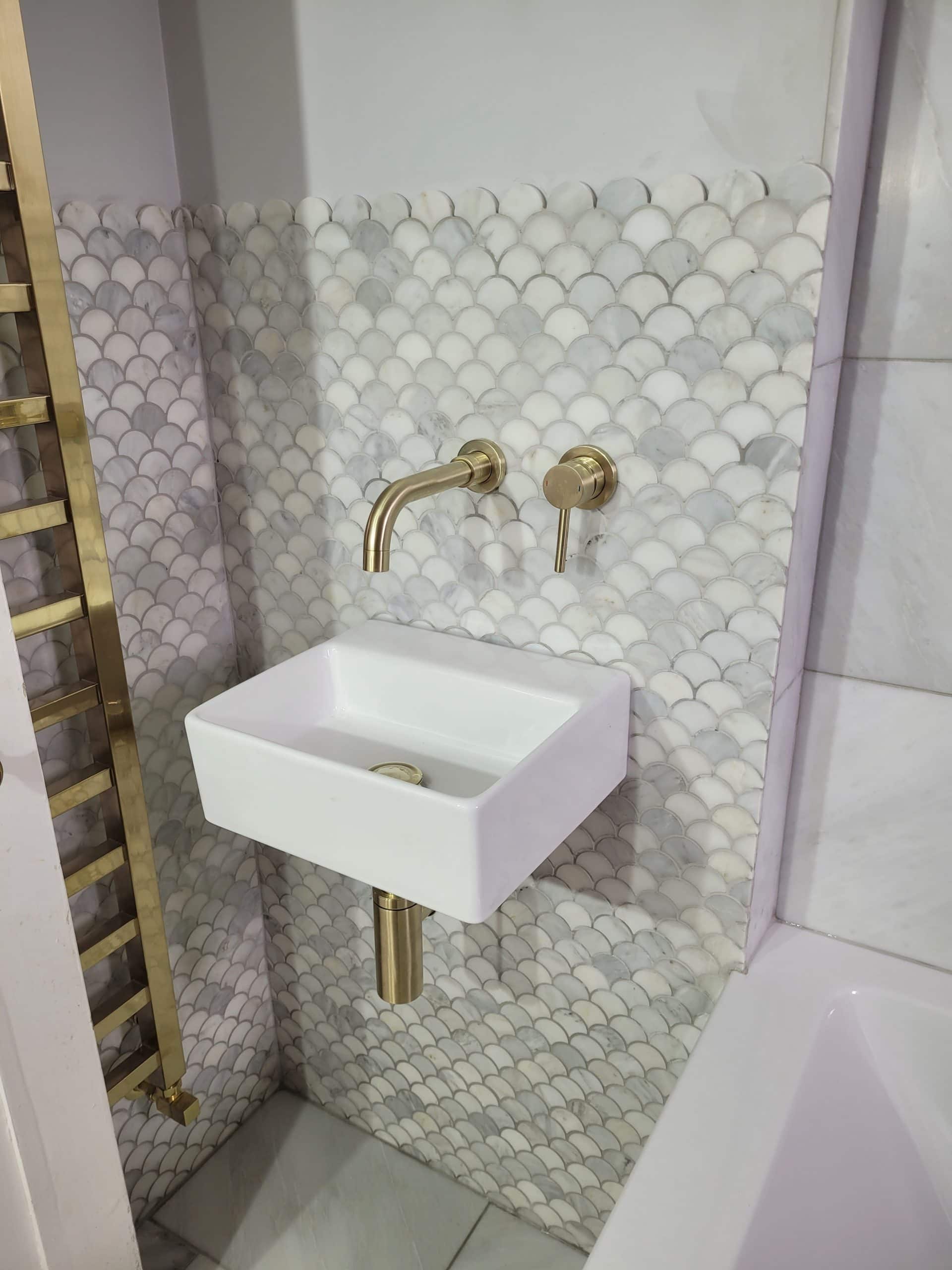 Wall-hung basin with bronze fixtures